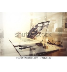 Office workplace with laptop and smart phone on wood table and london city blurred background